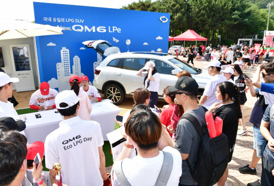 인천 SK행복드림구장에 전시된 르노삼성자동차 더 뉴 QM6 LPe를 살펴보는 관람객들.  르노삼성자동차 제공